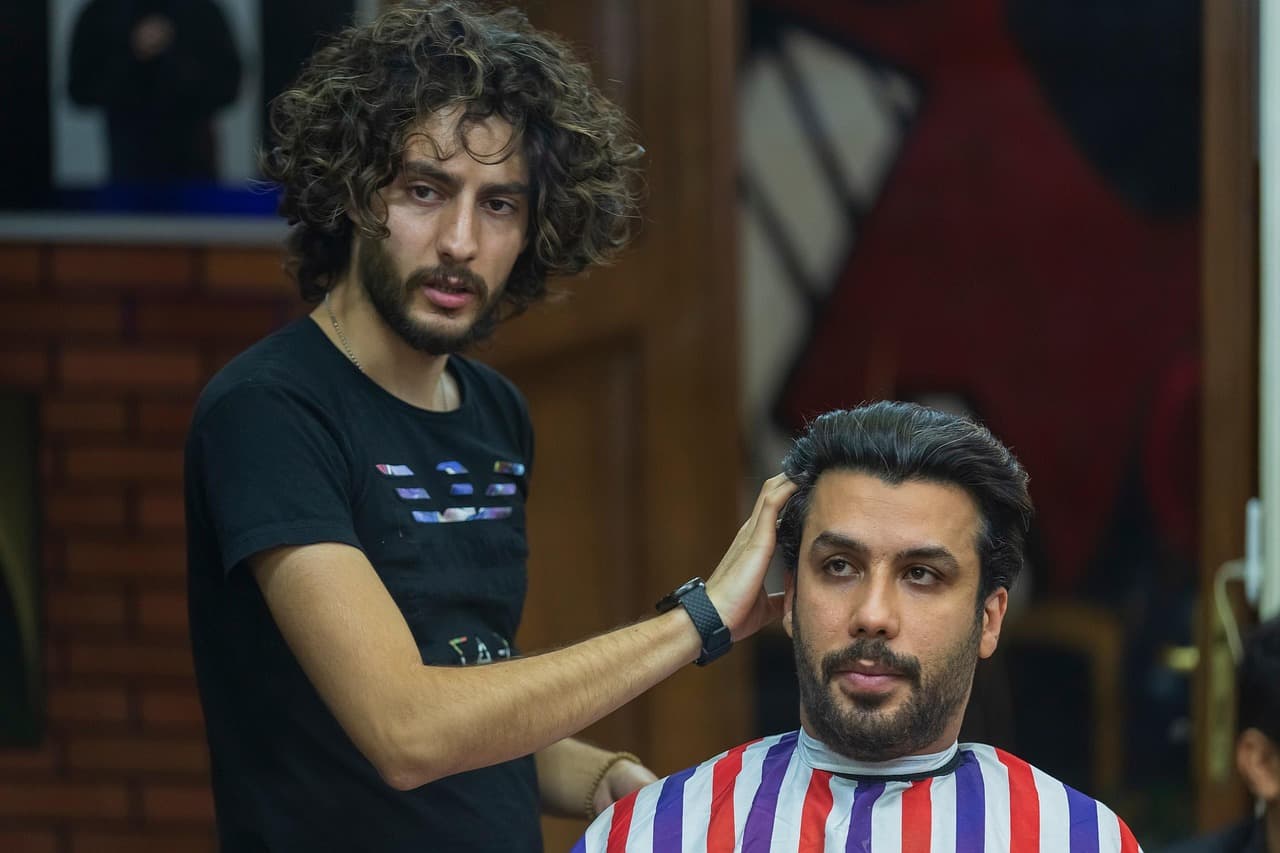 Barber checking a customer’s cut in the mirror