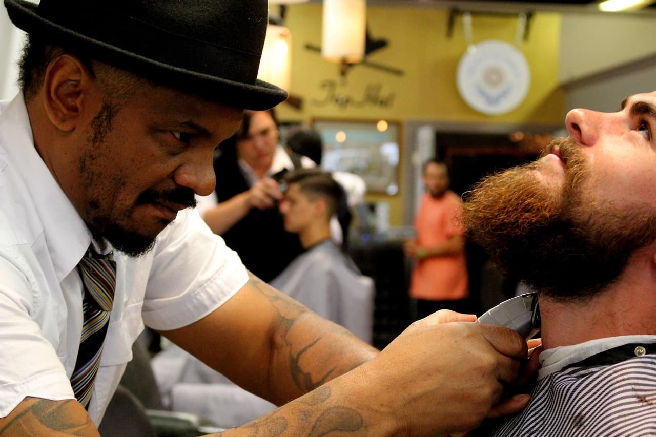 Barber trimming and shaping a full beard