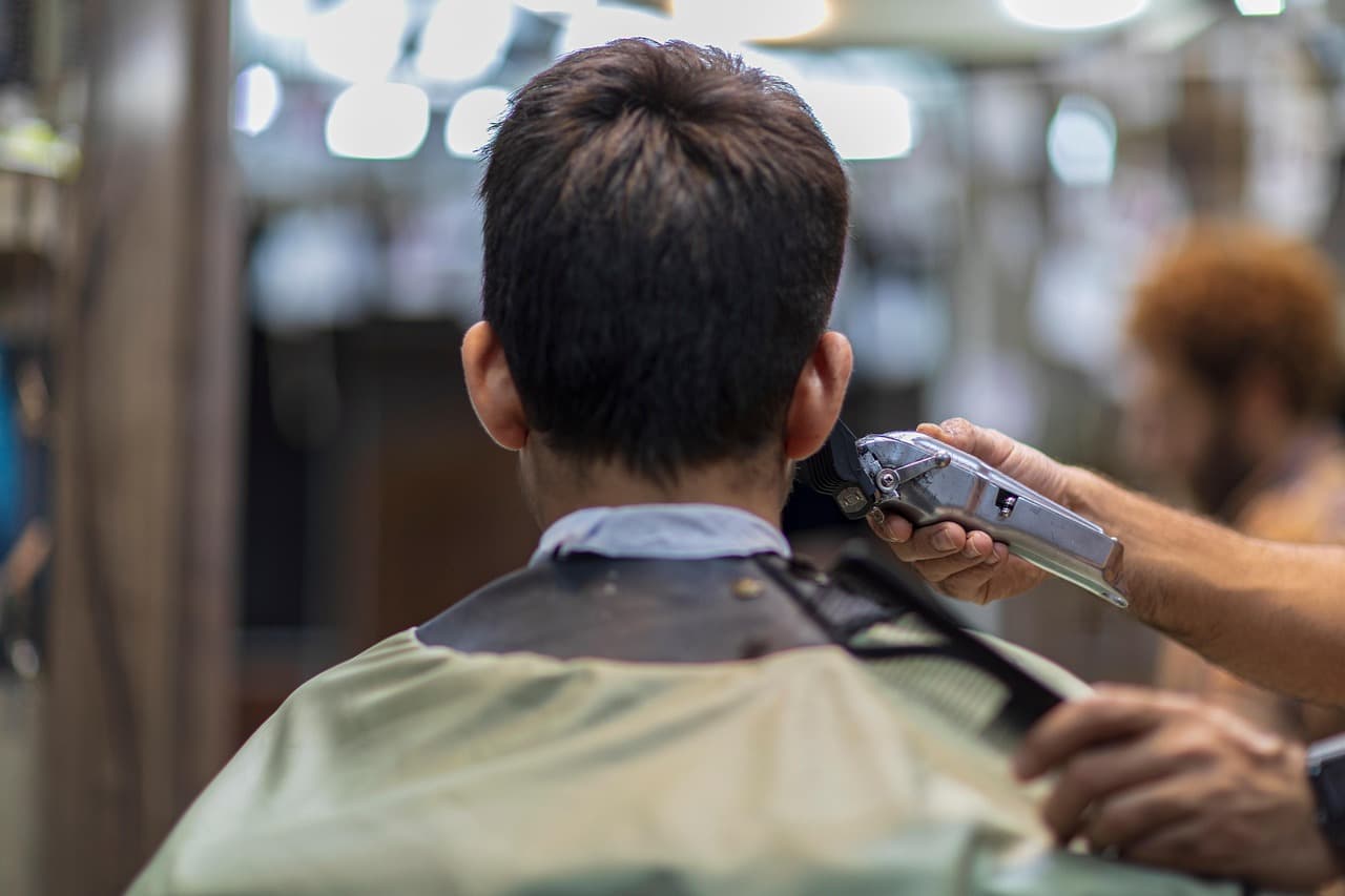 Barber working clippers up the back of a customer’s head